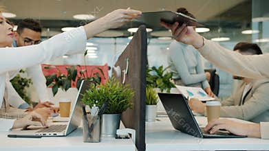 Slow motion of multi-ethnic team working in open space office talking using computers