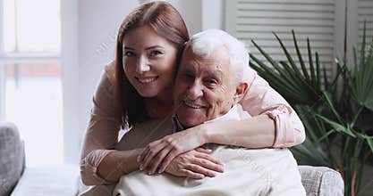 Smiling beautiful grownup daughter cuddling happy middle aged older father.