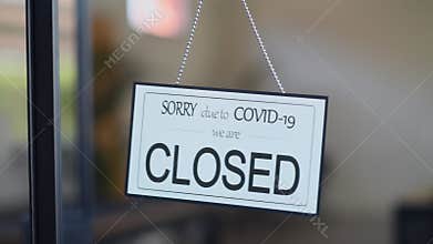 Closed sign hanging on door of cafe due to Covid-19