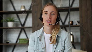 Woman in headset look at camera talking using videocall