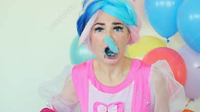 Girl eats blue cotton candy entertaining kids at birthday
