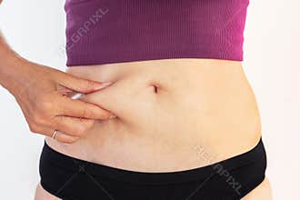 Mature woman pinching her belly fat body care and fitness concept