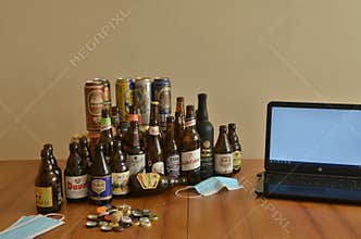 Assortment of artisan beer bottles and cans on table. Drinking at home in pandemic times. Work from home.