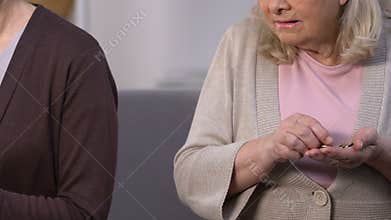 Poor old lady counting cents, rich aged female holding dollars bundle, injustice
