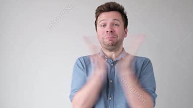 Young caucasian man clapping hands,being excited with news