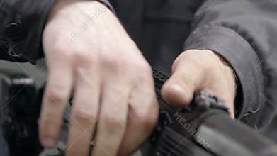 Factory assembly of a Kalashnikov assault rifle. Unlocking assault rifle. Factory worker hand charging machine gun