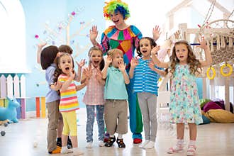 Clown and children playing indoor . Holiday in a children`s club. Games with animator