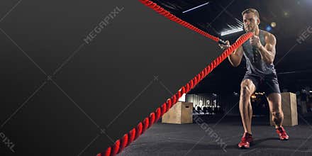 Young healthy man athlete doing exercise in the gym with ropes, flyer with copyspace
