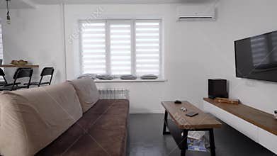 Nordic style in interior of small cozy apartment, moving view on living room with resting zone