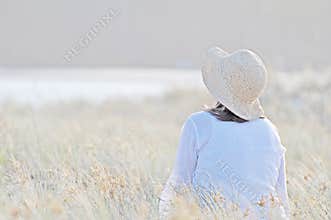 Romantic woman sitting in tall long grass