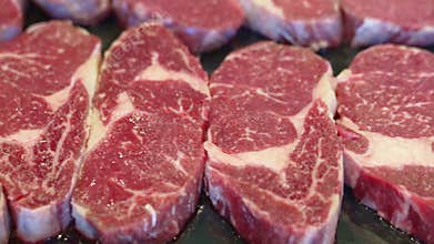 sliced pieces of raw meat to make fried steaks on baking tray.