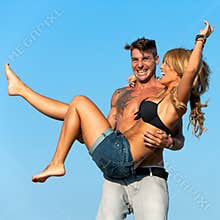 Boyfriend holding girlfriend in his arms.