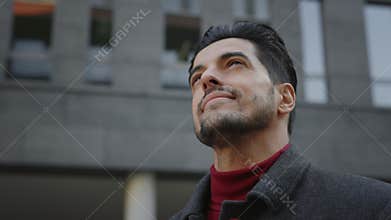Handsome multi ethnic man is enjoying the city, thinking dreaming about something. Multi raced student utdoors looking