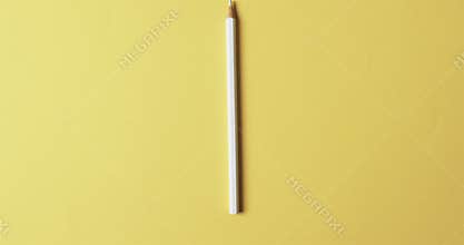 Overhead view of white crayon with copy space on yellow background, in slow motion