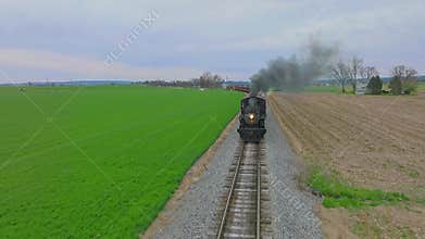 Head on Drone View of an Antique Steam Passenger Train Approaching While Traveling Thru Farmlands