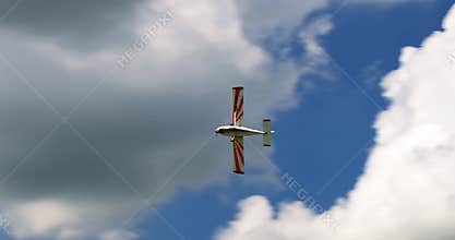 Classic light propeller planes flying in a sunny blue sky with white clouds