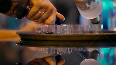 Pouring alcohol in shots on the tray