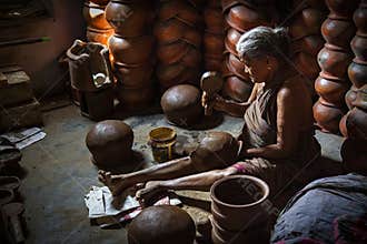 elderly woman making hand made mud pot