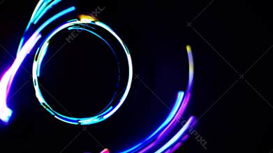 Light trails swirling into a vibrant circle against a dark backdrop, conveying dynamic movement and energy through a spectrum of