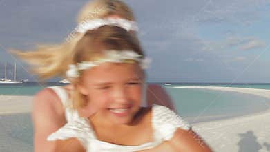 Bride Spinnning Bridesmaid Around At Beach Wedding