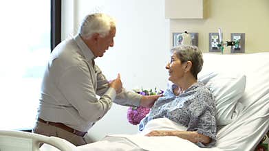 Senior Man Visiting Wife In Hospital Room