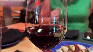 Vertical. Gathering of cheerful young friends toasting celebrating BBQ dinner on rooftop terrace. People drinking wine