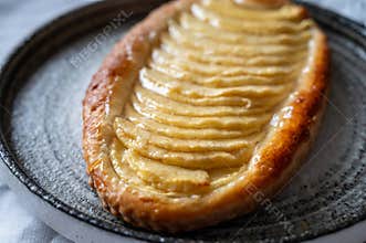 French fresh baked sweet puff pastry with fresh apple fruits in sirup in confectionery shop