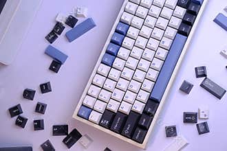 Close Up Modern 75% Layout Mechanical Keyboard with White, Blue, and Black Keycaps on a Clean White Desk