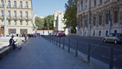 Blurred street scene in marseilles showing people relaxing outdoors with scooters on a sunny day capturing the vibrant urban