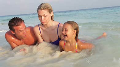 Family Relaxing On Tropical Beach