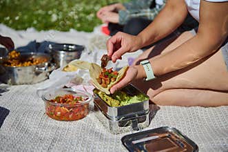 Mother Preparing Tacos During a Family Picnic on a Sunny Summer Day