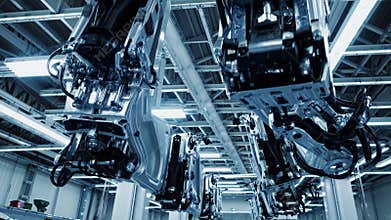 Robotic arms moving car body parts in automated factory