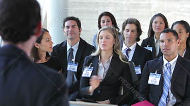 Businesspeople Listening To Speaker At Conference