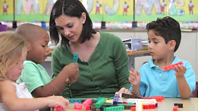Teacher Sits With Group Of Children Using Construction Kit