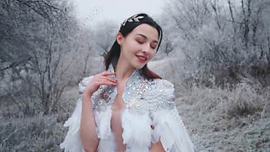 Happy beautiful fantasy woman snow queen in forest. Smiling face princess