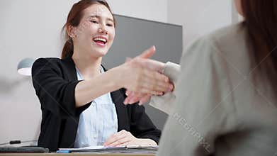 Young asian recruiter job interview examining with candidate with success and handshake in office, human resources hiring, HR