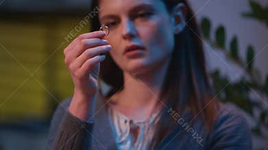Caucasian woman sad at home night evening upset take off wedding ring frustrated girl female wife regret thinking