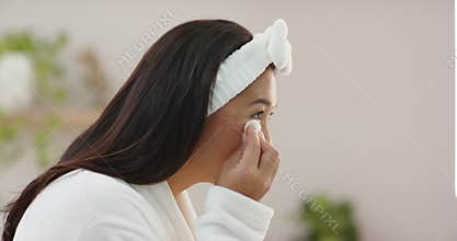 Opening cleansing pad container, woman is dabbing under eye and wiping cheekbone to cleanse skin