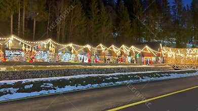 Christmas market stalls illuminated at night along road