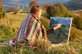 Young artist painting an autumn landscape