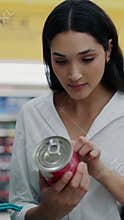 Dietician Monitors Calories On The Can While Standing In The Supermarket.
