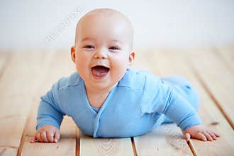 Cute happy baby boy crawling on the floor