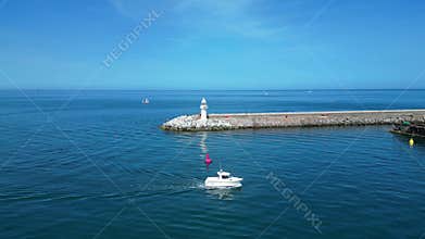 Brixham, Torbay, South Devon, England: DRONE VIEWS: Brixham Harbour lighthouse, the Outer Harbour Wall and various boats