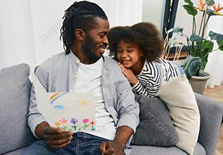 Dad is happy to receive a greeting card with a child\'s drawing from his daughter to father\'s day