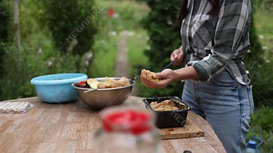 Woman preparing marinated chicken skewers for barbecue party