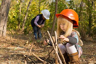 Two young children playing at being builders