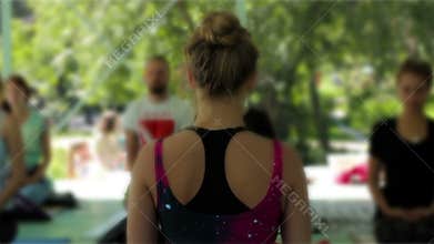 Yoga master class. Group meditation in the open air in the shade. Teacher`s back