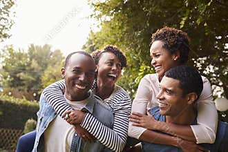 Two young adult black couples having fun piggybacking