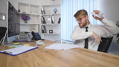 Angry businessman tearing papers in the office