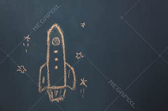 Flat lay Handmade drawing rocket ship launch / take off to the space with star on the blackboard by chalk board.